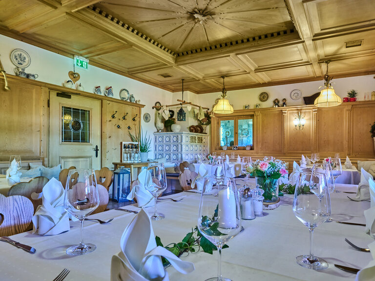 Traditionelle Gaststube, mit eingedeckten Tisch mit Servietten und Rosen