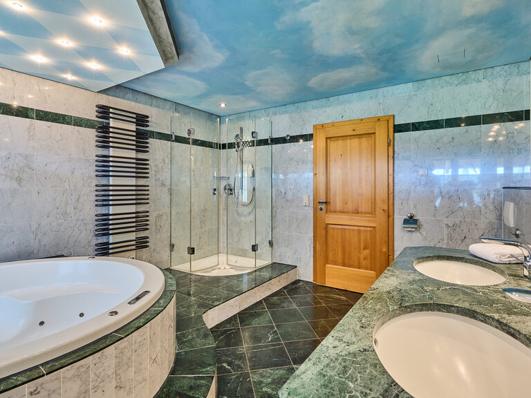 Luxuriöses Badezimmer mit Whirlpool und edlen Fliesen im Hotel Happinger Hof in Bayern