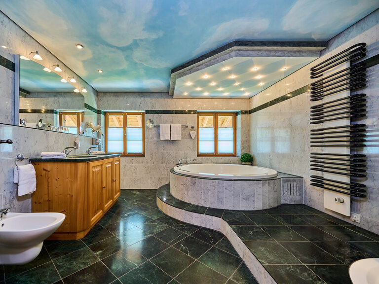 Ein Luxuriöses Badezimmer mit Whirlpool und schicken Fliesen im Hotel Happinger Hof in Rosenheim