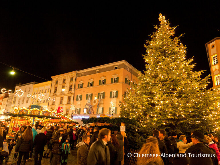 Weihnachtsmarkt, beleuchtet und beschmückt mit großem Christbaum bei Nacht
