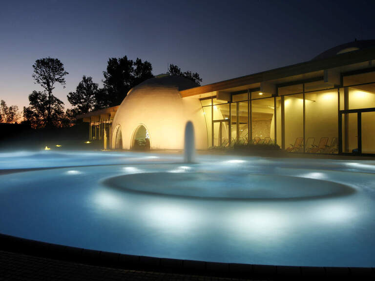 Außenbecken von Therme, beleuchtet bei Dämmerung