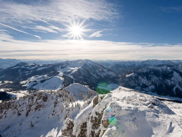 Beschneites Gebirge im Winter nahe dem Hotel & Landgasthof Happinger Hof nahe dem Chiemsee Beschneites Gebirge mit Wäldern im Winter, darüber Sonn