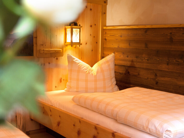 Nahaufnahme eines einladenden Betts im Kranzhorn Twinbettzimmer mit gemütlicher Beleuchtung