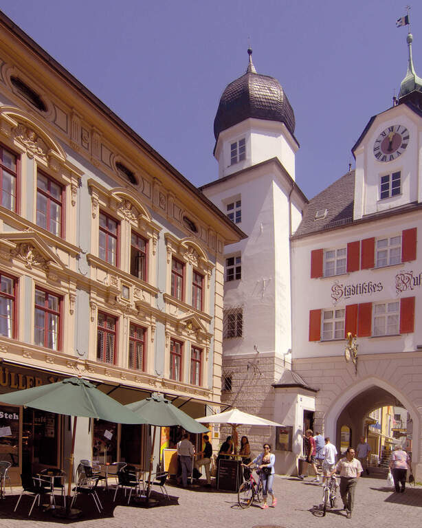 Mehrere Gebäude und eine Kirche in der Innenstadt in Rosenheim an einem Sommertag