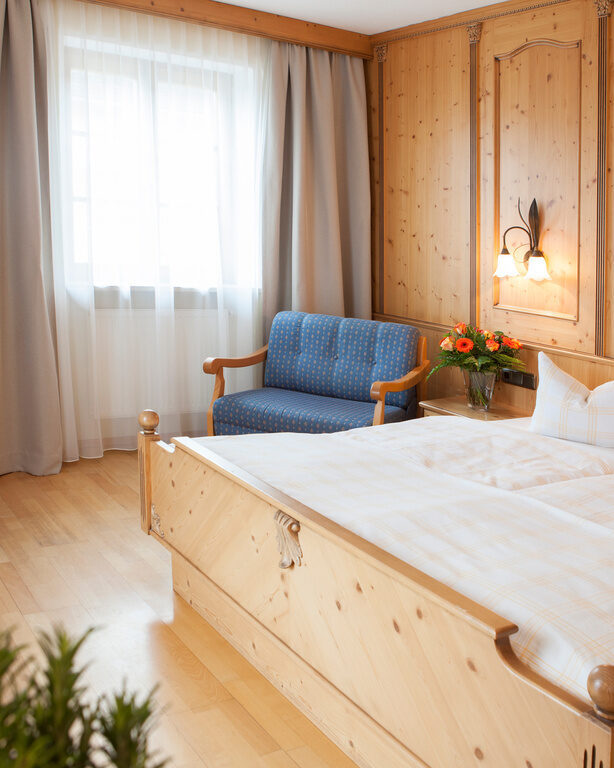 Das einladende, helle Schlafzimmer im Landgasthof Doppelzimmer mit verschiedenen Holzmöbeln und gemütlichen Doppelbett