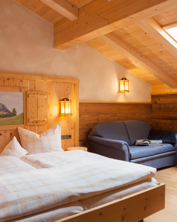 Das helle Schlafzimmer im Heuberg Doppelzimmer des Hotels Happinger Hof mit Doppelbett und Dachfenster.