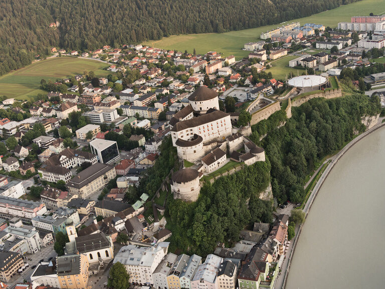 Drohnenaufnahme von Festung Hohensalzburg nahe dem 3-Sterne-S-Hotel und Landgasthof Happinger Hof beim Chiemsee Luftaufnahme von historischer Festung in Österreich, Salzburg, daneben Fluss