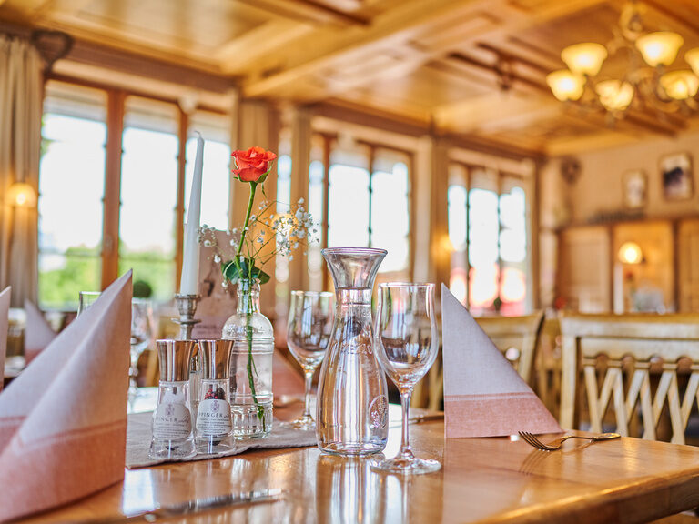 Gedeckter Tisch im Wintergarten des Hote und Landgasthof Happinger Hof nahe dem Chiemsee Gedeckter Tisch mit Servietten, Wasserkaraffe- und Gläsern in hellem Wintergarten