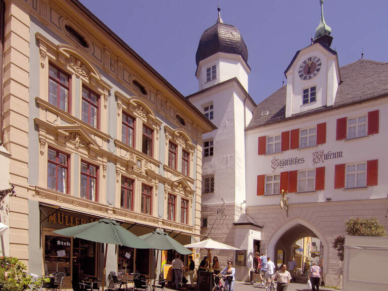 Mehrere Gebäude und eine Kirche in der Innenstadt in Rosenheim an einem Sommertag