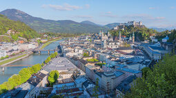 Eine Luftaufnahme der Salzburger Innenstadt mit Salzach und Burg im Bild