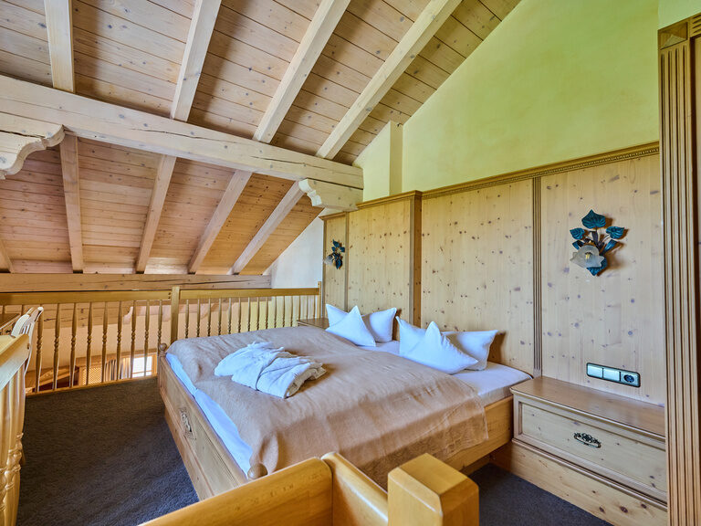 Der einladende Schlafensbereich mit Doppelbett in der Prinz Luitpold Suite im Hotel Happinger Hof in Rosenheim