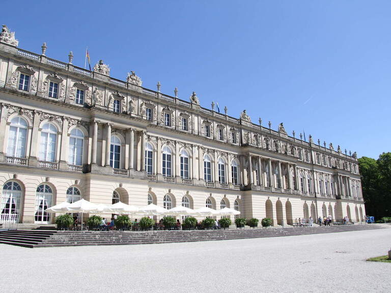 Großer antiker Wasser-Springbrunnen, dahinter Schloss Herrenchiemsee