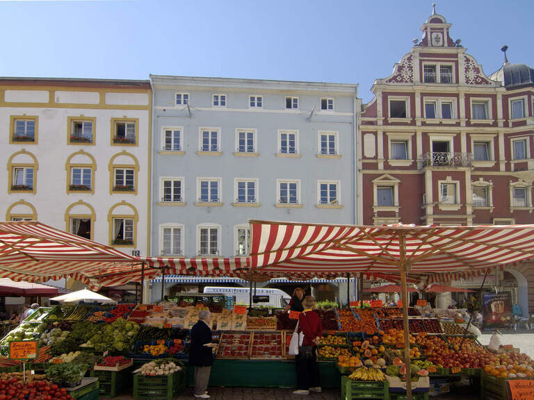 Wochenmarkt mit Obstständen nahe dem 3-Sterne-S-Hotel und Landgasthof Happinger Hof beim Chiemsee Wochenmarkt in bayerischer Altstadtmit vielen Obstständen, großen gestreiften Sonnenschirmen
